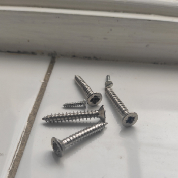 Different sized screws on a tile